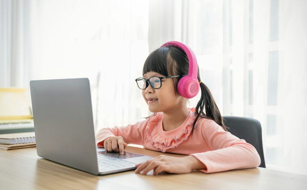 Portrait of Asian girl using computer to learn lessons in elementary school