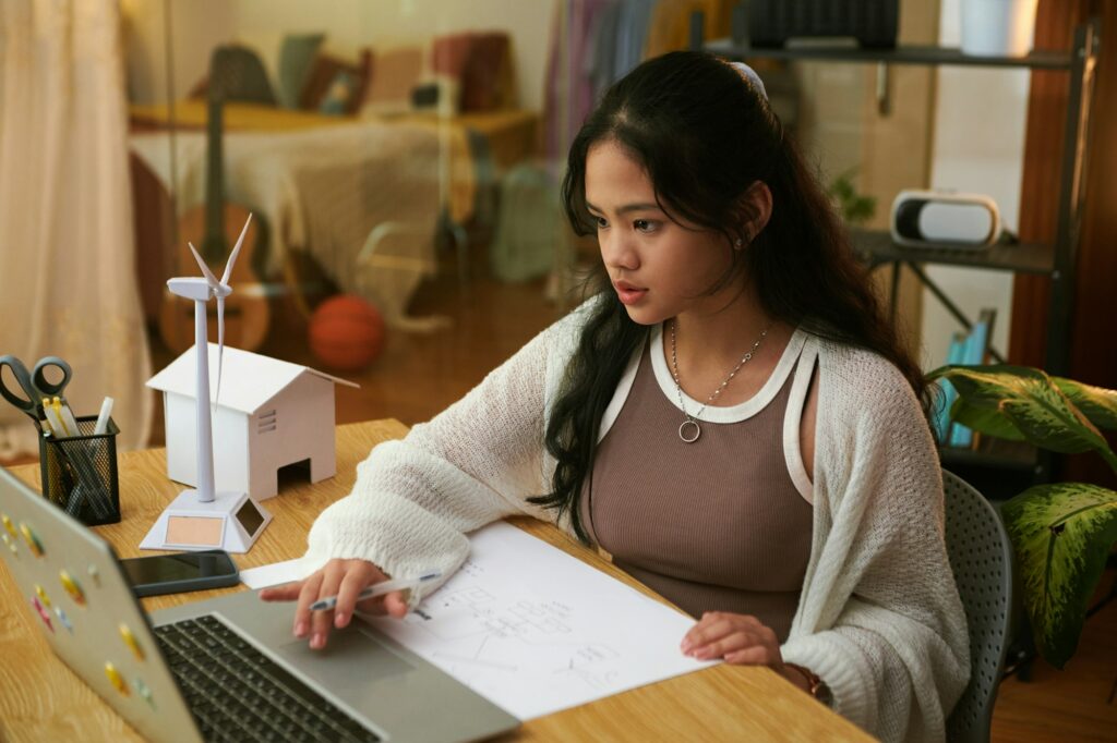 Schoolgirl studying at home, learning about green energy sources