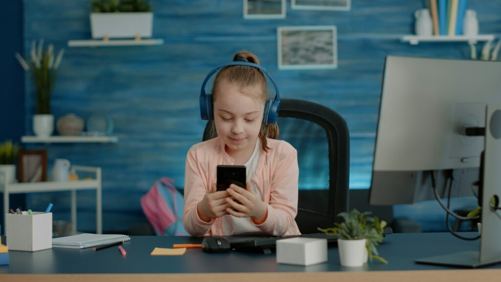 Schoolgirl using video call on smartphone for school courses