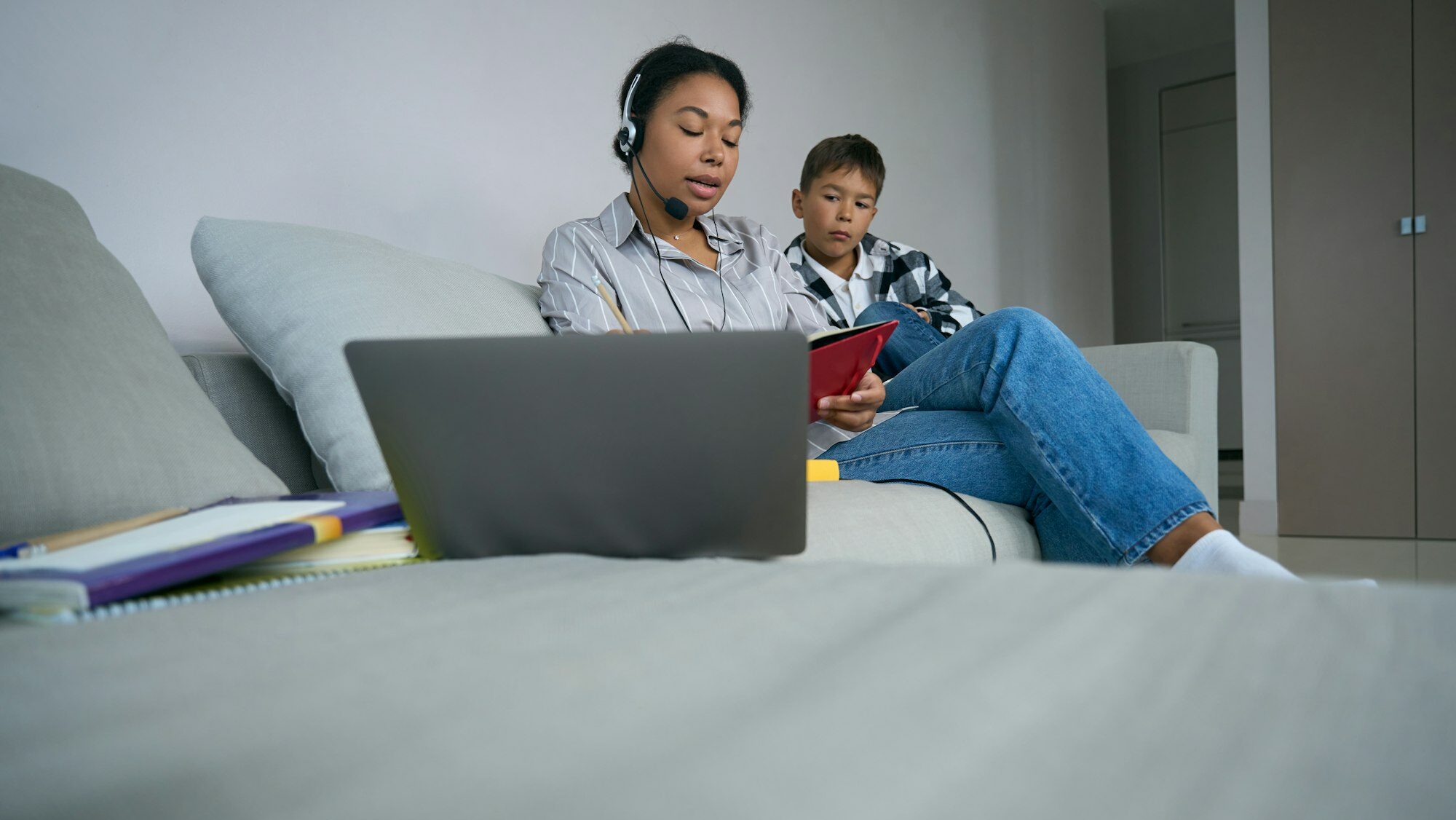 Boy watches his mother take online courses at home